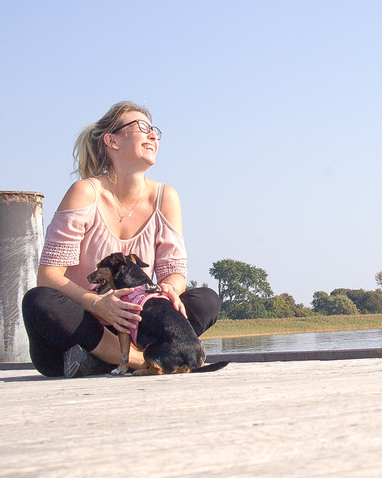 Bloginhaberin Jacky mit Hund an einem Steg an der Ostsee
